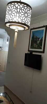 a chandelier hanging from a wall with a picture at Dar Kouzzou in Marrakech