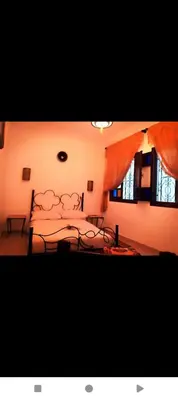 a bedroom with a bed and two windows at Dar Kouzzou in Marrakech