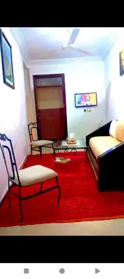a living room with a couch and a red rug at Dar Kouzzou in Marrakech