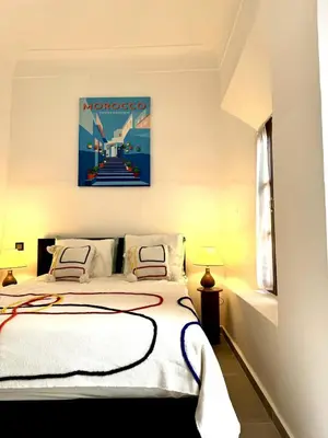 a bedroom with a bed and a painting on the wall at Riad Nabil with Concierge and FREE Breakfast in Marrakech