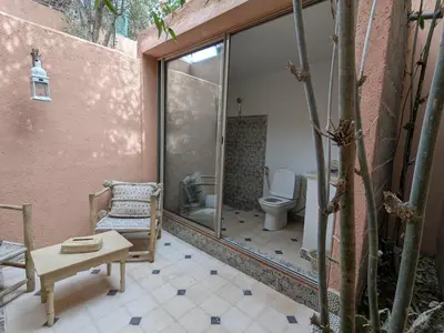a bathroom with a toilet and a chair and a table at the old house in Marrakech