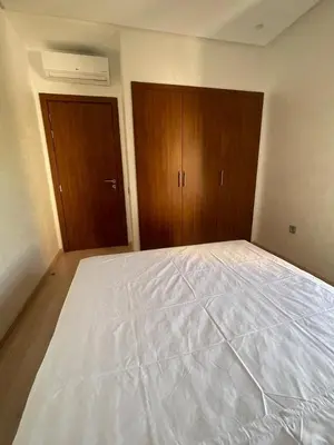 a large white bed in a room with wooden cabinets at Oasis des Lumières in Marrakech