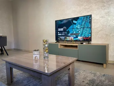 a living room with a coffee table and a flat screen tv at Stylish Appart near the centre in Marrakech