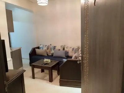 a living room with a blue couch and a table at Studio Au Centre Ville Marrakech in Marrakech