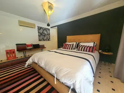 a bedroom with a large bed with two pillows at Family villa pool sauna and hammam in Marrakech