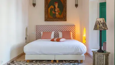 a bedroom with a bed and a painting on the wall at Dar Salam Marrakech in Marrakech