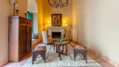 a room with a table and chairs and a fireplace at Dar Salam Marrakech in Marrakech