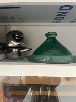 a green glass jar sitting on a shelf at Au cœur de la ville ocre in Marrakech