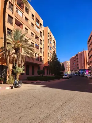a city street with a palm tree and a building at MARRAKECH CENTRE Appartement in Marrakech