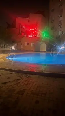 a night view of a swimming pool with red and green lights at Authentic Apartment Riad style in Marrakech in Marrakech