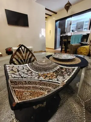 a table with two plates on it in a living room at Authentic Apartment Riad style in Marrakech in Marrakech