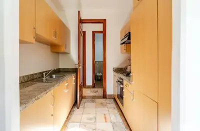 a kitchen with wooden cabinets and a tile floor at Prestige authentique in Marrakech