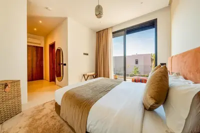 a bedroom with a large bed and a large window at Luxury 5-Star Villa - Games & Activities - 15 min to Center in Marrakech