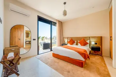 a bedroom with a large bed and a mirror at Luxury 5-Star Villa - Games & Activities - 15 min to Center in Marrakech