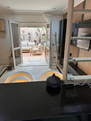 a kitchen with a table and a living room at Duplex Sur Marrakech Guéliz in Marrakech