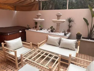 a patio with two chairs and a fountain at Duplex Sur Marrakech Guéliz in Marrakech