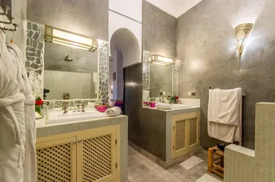 a bathroom with two sinks and a large mirror at Dar Charkia in Marrakech