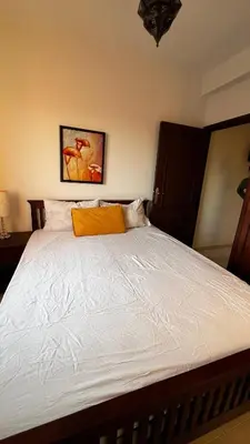 a bed with an orange pillow on top of it at Bright with great view in Marrakech