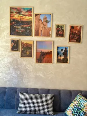 a group of pictures on a wall above a couch at Cozy Apt Near Marrakech Airport in Marrakech