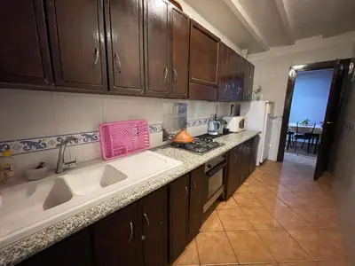a kitchen with brown cabinets and a pink basket on the counter at Le grand jardin Marrakech in Marrakech