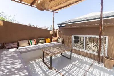 a patio with a wooden bench on a balcony at HM40 I Moroccan Riad with Residential Pool in Marrakech