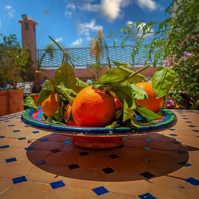 a pile of oranges on a plate on a table at Riad Dar Mamouni in Marrakech