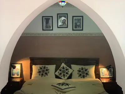 a bedroom with an archway with a bed with pillows at Riad Dar Mamouni in Marrakech