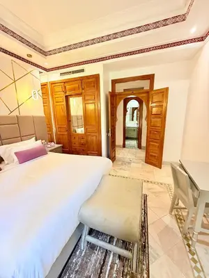 a bedroom with a large bed and a desk at VILLA 34 - 4 Masters, Moroccan Charm & Modern Comfort with Private Pool in Marrakech