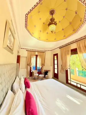 a bedroom with a large bed and a chandelier at VILLA 34 - 4 Masters, Moroccan Charm & Modern Comfort with Private Pool in Marrakech