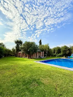 a large yard with a swimming pool in front of a house at VILLA 34 - 4 Masters, Moroccan Charm & Modern Comfort with Private Pool in Marrakech