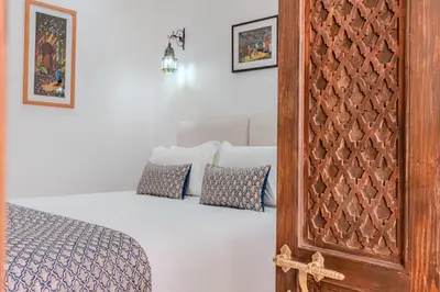 a bedroom with a bed and a wooden cabinet at Riad Dar Amarena Exclusif BreakFast in Marrakech