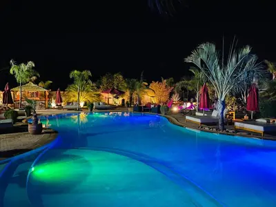 a swimming pool at night with blue illumination at Eden Lodges & SPA-Boutique Hôtel de Luxe in Marrakech