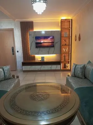 a living room with a large tv on the wall at Charming Marrakech apartment in Marrakech