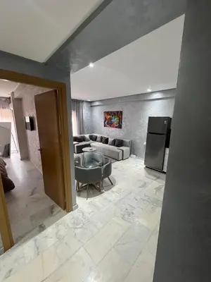 a living room with a couch and a refrigerator at Superbe appartement T2 plein centre de Marrakech in Marrakech