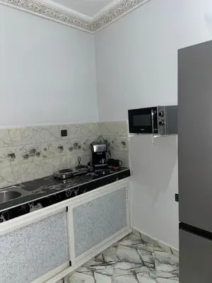 a white kitchen with a stove and a refrigerator at Marrakech Oasis Retreat in Marrakech