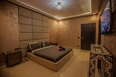 a bedroom with a bed and a flat screen tv at Villa Athena 4 chambres piscine privée et jaccuzi in Marrakech