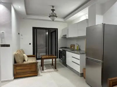a kitchen with a refrigerator and a chair in it at appartement Lamrani in Marrakech