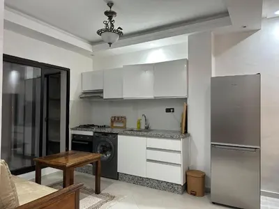 a kitchen with white cabinets and a washer at appartement Lamrani in Marrakech