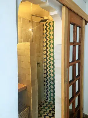 a shower with a glass door in a bathroom at Riad Dar Wildeve in Marrakech