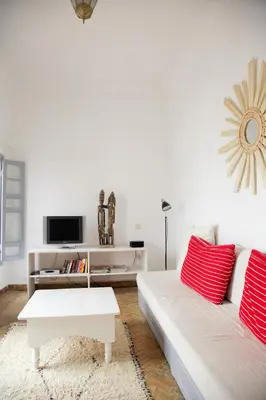 a living room with a white couch and red pillows at Riad Dar Wildeve in Marrakech