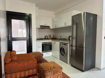 a kitchen with a stainless steel refrigerator and a couch at appartement Meryam in Marrakech