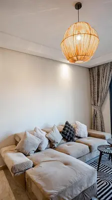 a living room with a couch and a chandelier at Grand T2, terrasse au coeur de Gueliz in Marrakech