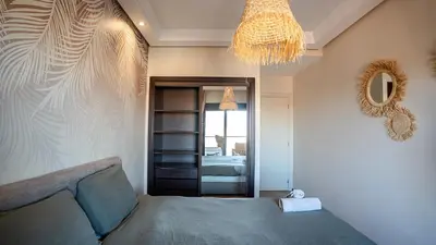 a bedroom with a bed and a chandelier at Grand T2, terrasse au coeur de Gueliz in Marrakech