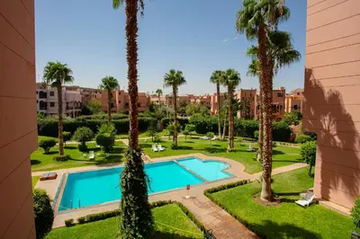 an overhead view of a swimming pool in a park with palm trees at Artisan's Hideaway Marrakech in Marrakech