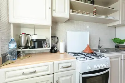a kitchen with white cabinets and a stove top oven at Artisan's Hideaway Marrakech in Marrakech