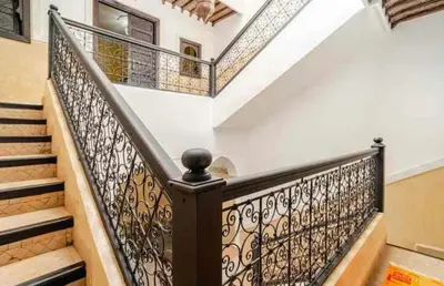 a staircase with a wrought iron railing in a house at Riad Amani in Marrakech