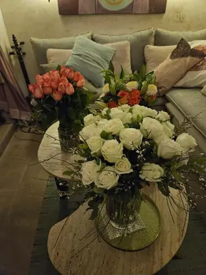 two vases of flowers on a table in front of a couch at Séjour au cœur de la medina in Marrakech