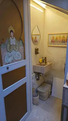 a bathroom with a sink and a painting on the wall at Séjour au cœur de la medina in Marrakech