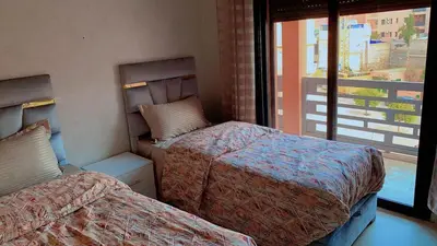 a room with two beds and a window at Hivernage Cosy in Marrakech
