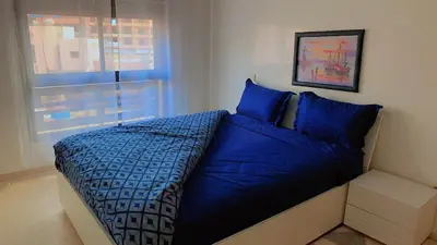 a blue bed in a room with a window at Hivernage Cosy in Marrakech